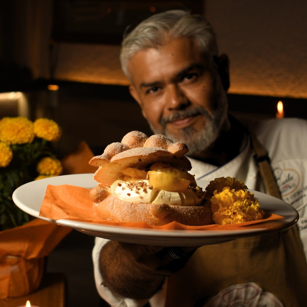 Chef de Karla Bistro presenta un pan de muerto relleno, foto producida para sus redes sociales